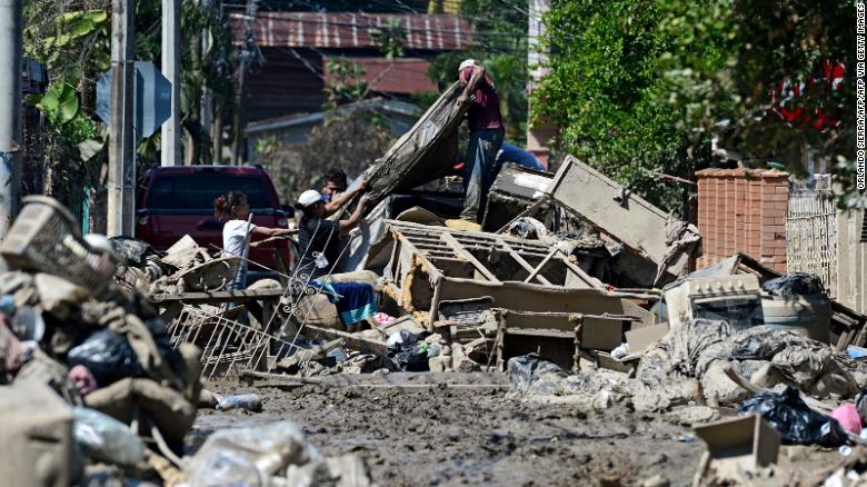 People try to recover belongings amid mud after the passage of Hurricane Eta as they prepare to evacuate the Omonita neighborhood in El Progreso, Yoro department, Honduras.