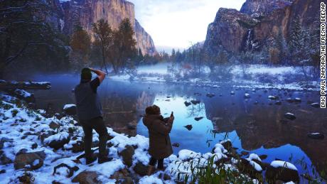 Erick Jensen (left), of Seattle, and Ruth Reyes (right), of LA, take in the Yosemite Valley November 9, following the weekend&#39;s snowstorm in Yosemite National Park, California. 