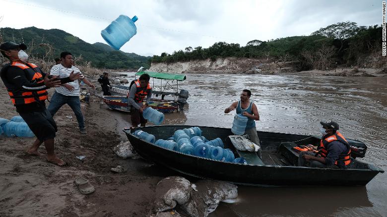 People from San Rafael colony in Honduras prepare for the water shortage as they cross the Ulua River to evacuate Monday. 