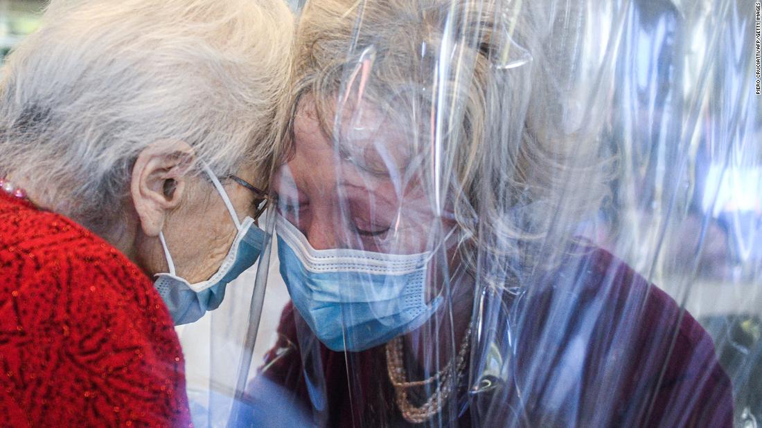 A nursing-home resident, left, speaks with her visiting daughter through a plastic screen in Castelfranco Veneto, Italy, on November 11. The plastic screen is part of a &quot;Hug Room&quot; that allows residents and their families to embrace each other during the coronavirus pandemic.