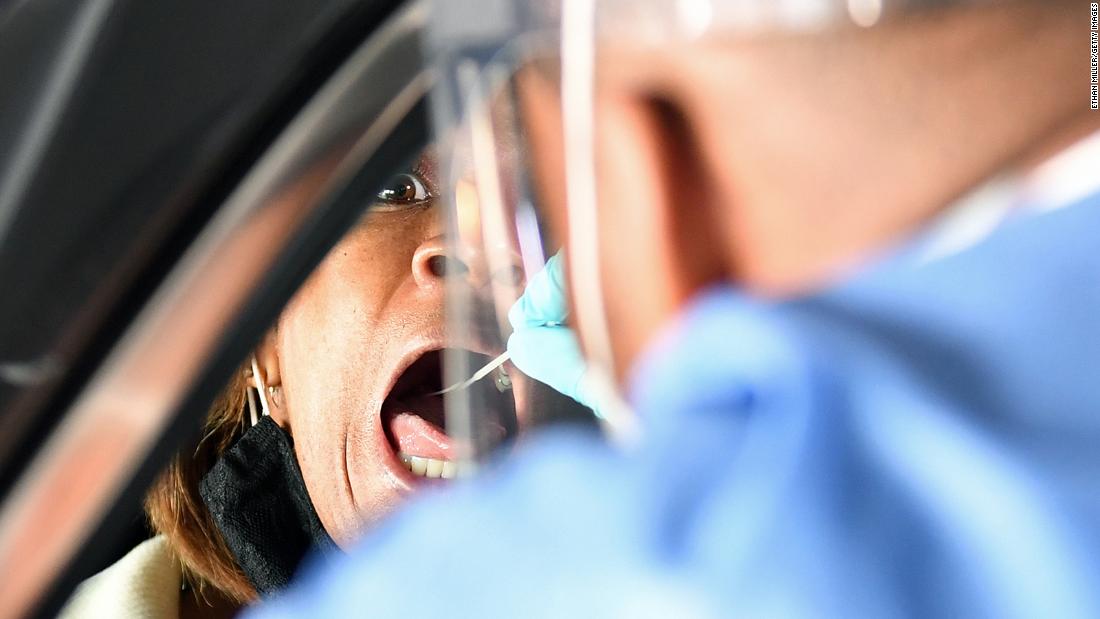 Spc. Demetrie Barnett of the Nevada National Guard administers a Covid-19 test to North Las Vegas City Councilwoman Pamela Goynes-Brown during a preview of a free drive-thru testing site on November 12.