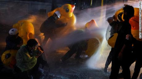 Demonstrators use inflatable rubber ducks as shields to defend themselves from water cannons during an anti-government demonstration in front of the Bangkok Parliament on 17 November 2020. 