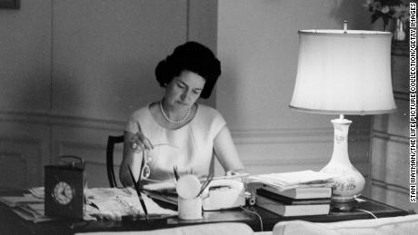 Lady Bird Johnson sits at a White House table in 1964.