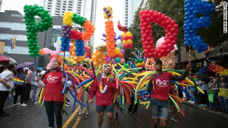 Employees from a local business support LGBTQ rights march during the city&#39;s annual Gay Pride parade on Sunday, October 13, 2019, in Atlanta.