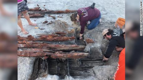 Dorothy Rowland and Nick Budsberg, both members of the St. Augustine Lighthouse Archaeological Maritime Program, examine the shipwreck on Crescent Beach.