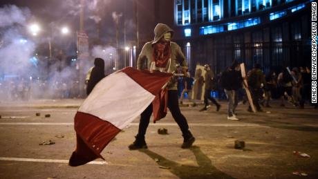 A demonstrator, supporter of Peruvian ousted President Martin Vizcarra, holds a Peruvian flag during clashes on November 14, 2020.