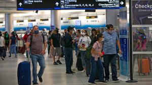 Travelers wearing protective face masks walking through Concourse D at the Miami International Airport on Sunday, November 22, 2020 in Miami, Florida. With the coronavirus surging out of control, the nation&amp;apos;s top public health agency pleaded with Americans not to travel for Thanksgiving and not to spend the holiday with people from outside their household. (David Santiago/Miami Herald/Tribune News Service via Getty Images)