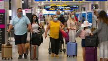 Travelers wearing protective face masks walking through Concourse D at the Miami International Airport on Sunday, Nov. 22, 2020, in Miami, Fla. With the coronavirus surging out of control, the nation&#39;s top public health agency pleaded with Americans not to travel for Thanksgiving and not to spend the holiday with people from outside their household. (David Santiago/Miami Herald via AP)