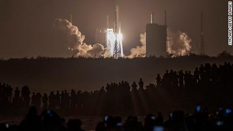 Crowds watch in the early hours of the morning as the rocket carrying Chang&#39;e-5 launches. 