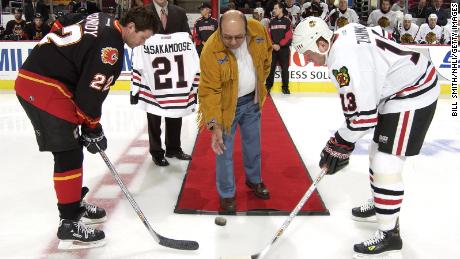 Craig Conroy #22 of the Calgary Flames and Alexei Zhamnov #13 of the Chicago Blackhawks pose for the ceremonial face off being dropped by Fred Sasakamoose at the United Center on October 19, 2002.