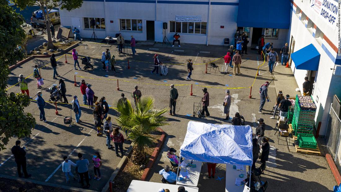 People wait in line to receive food at the Bay Area Rescue Mission&#39;s Thanksgiving Giveaway in Richmond, California.