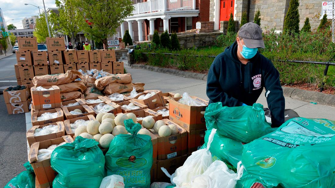 Volunteers load plastic bags with food in Everett, Massachusetts, during a weekly food pantry service run by Grace Ministries of the North Shore.