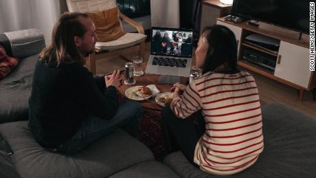 A couple celebrates Thanksgiving with friends by having dinner together over a Zoom video call on November 22, 2020, in New York.