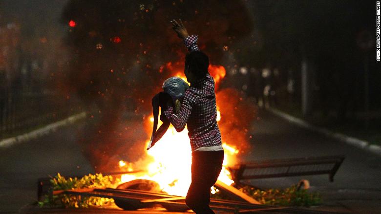 A man demonstrates in front of a bonfire during a protest against the death of Joao Alberto in Porto Alegre, Brazil on November 23, 2020. 