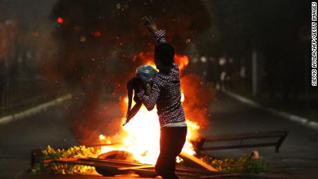 A man demonstrates in front of a bonfire during a protest against the death of Joao Alberto in Porto Alegre, Brazil on November 23, 2020. 