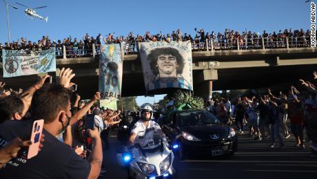 Mourning fans wave from an overpass at the caravan carrying the remains of Diego Maradona to his resting place in Buenos Aires on Thursday.