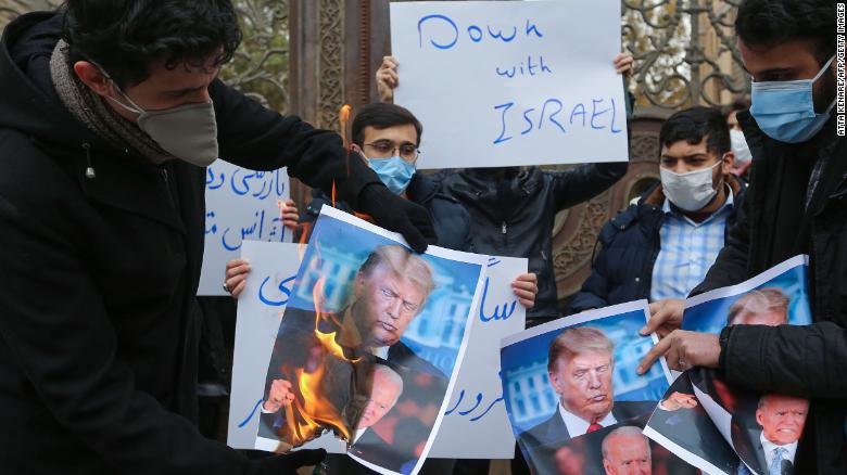 Students of Iran's Basij paramilitary force burn posters depicting Donald Trump and Joe Biden during at the foreign ministry in Tehran, on November 28, 2020, to protest the killing of prominent nuclear scientist Mohsen Fakhrizadeh a day earlier near the capital.
