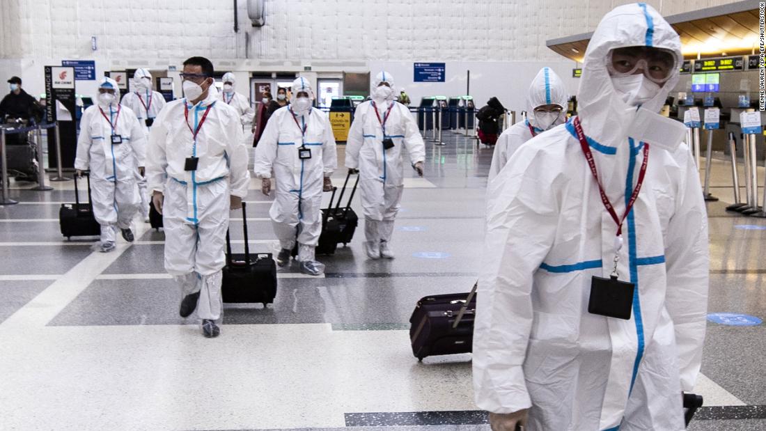 Airline crew members wearing protective suits arrive at Los Angeles International Airport on November 24.