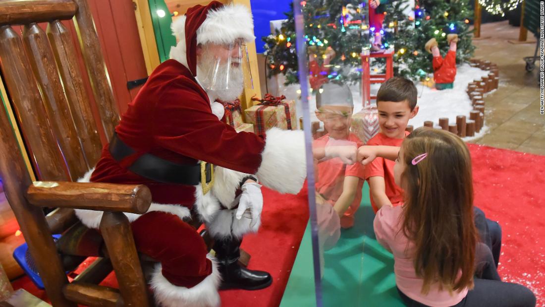 Cali Hammer fist-bumps Santa, who was behind a plexiglass partition at a Cabela&#39;s store in Tilden Township, Pennsylvania, on November 20.