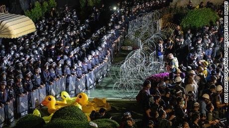 Assault police are guarding barbed wire and inflatable yellow ducks at an anti-government protest in the Thai capital. 