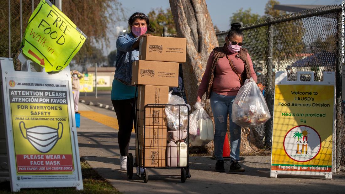 Two women take home free meals after waiting in a long line at a high school in South Gate, California, on November 25.