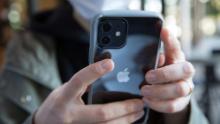 A woman holds the new iPhone 12 in her hands. 