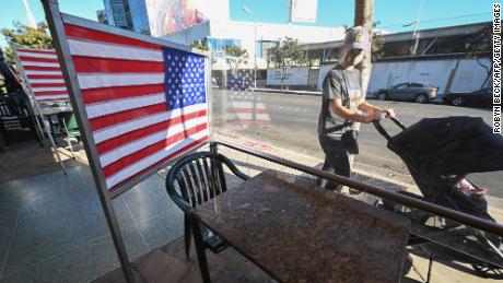 Empty patio tables separated by plastic dividers adorned with American flags are seen at Mel&#39;s drive-in diner in West Hollywood, California on November 30, 2020, after Los Angeles County banned outdoor dining in an attempt to stem the latest surge in coronavirus cases. - Many restaurant owners, who have already spent thousands of dollars to ensure a safe and compliant outdoor dining experience, say the latest shut down of outdoor dining with be financially devastating. (Photo by Robyn Beck/AFP/Getty Images)