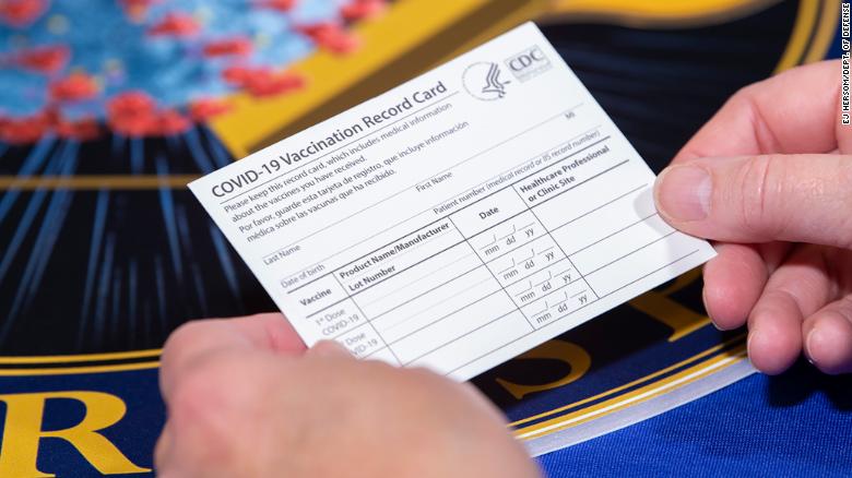 A Department of Health and Human Services employee holds a Covid-19 vaccine record card November 13 in Washington, DC.