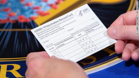 A Department of Health and Human Services employee holds a Covid-19 vaccine record card November 13 in Washington, DC. 