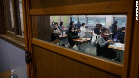 Students wearing face masks wait for the start of the annual college entrance examination amid the coronavirus pandemic at an exam hall in Seoul, South Korea, on December 3, 2020. 