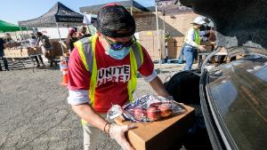 November 14, 2020, Los Angeles, California, USA: A volunteer loads food into the trunk of a vehicle during a &#39;&#39;Let&#39;s Feed L.A. County&#39;&#39; food distribution during the COVID19 crisis, Saturday, Nov. 14, 2020, in Burbank, Calif. (Credit Image: © Ringo Chiu/ZUMA Wire)