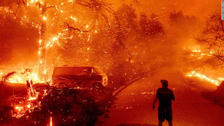 Bruce McDougal watches embers fly over his property as the Bond Fire burns through the Silverado community in Orange County, Calif., on Thursday, Dec. 3, 2020.