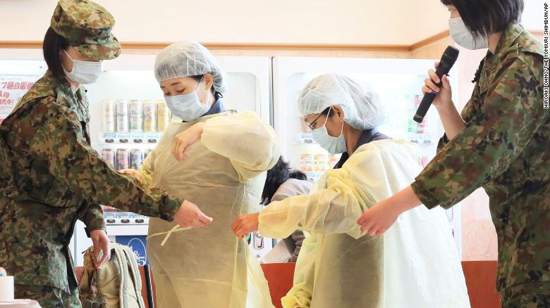 Officials are trained in putting on and taking off protective clothing by Self Defense Force (SDF) members in Japan&#39;s Kitakyushu City, Fukuoka Prefecture on April 10, 2020.