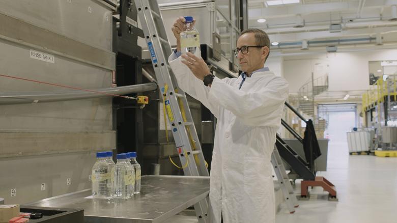 Joerg Hess, COO of Aquaporin A/S, checks water that has been filtered using the aquaporin membrane.