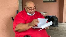 John Ayers looks through eviction documents as his eviction date looms.