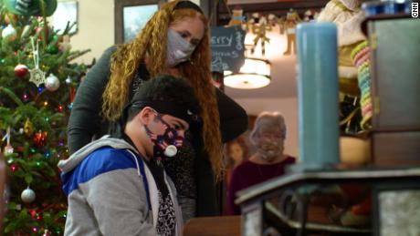 Angela Kearney watches her son Christian 14, play the piano.