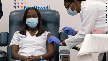 Sandra Lindsay, left, a nurse at Long Island Jewish Medical Center, is inoculated with the Pfizer-BioNTech COVID-19 vaccine by Dr. Michelle Chester, Monday, Dec. 14, 2020, in the Queens borough of New York. (AP Photo/Mark Lennihan, Pool)