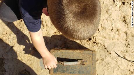 Dan DeJager&#39;s older son Hunter, 8, investigates a geocache the family found recently.
