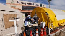 Emergency room tech Brenda de la Cruz registered nurse Janet Hays work on Dec. 8 outside St. Mary Medical Center in Apple Valley, California. The triage tents handle the overflow of patients.