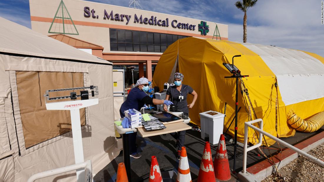 Emergency room tech Brenda de la Cruz registered nurse Janet Hays work on Dec. 8 outside St. Mary Medical Center in Apple Valley, California. The triage tents handle the overflow of patients.