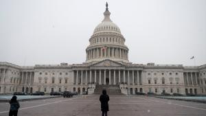 People walk past the US Capitol in Washington, DC on December 16, 2020. - Congressional leaders on December 16, 2020 said they were nearing a long-awaited agreement on a stimulus package for the US economy, while the Federal Reserve is set to provide updated forecasts on an uncertain outlook.A federal relief package to aid struggling business and jobless workers is seen as essential in getting the world&#39;s largest economy back on its feet amid a resurgence of Covid-19 infections. (Photo by Andrew Caballero-Reynolds/AFP/Getty Images)