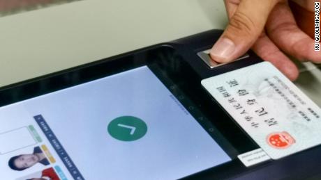 A student scanning their second-generation &quot;smart&quot; ID card at an exam site in July 2020 in Nanchang city.