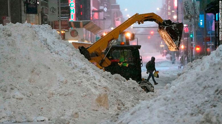 A snowplow pushes snow near Times Square on December 17, 2020 in New York, the morning after a powerful winter storm hit the US northeastern states.