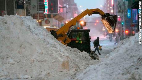 A snowplow pushes snow near Times Square on December 17, 2020 in New York, the morning after a powerful winter storm hit the US northeastern states.