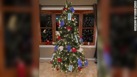 Moses Hoole decorated his Christmas tree with PPE this holiday season to honor his sister who is a health care worker. 