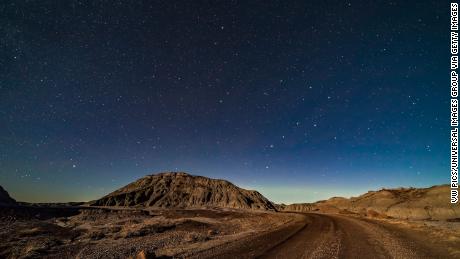 This image shows a moonlit night over the badlands loop road in Dinosaur Provincial Park in Alberta, Canada.