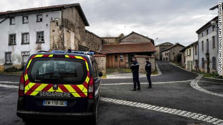 French gendarmes stand guard in a street in Saint-Just, central France on December 23, 2020, after three gendarmes were killed and a fourth wounded by a gunman they confronted in response to a domestic violence call.