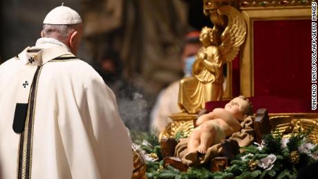 Francis prepares to kiss a figurine of baby Jesus during a Christmas Eve mass at St. Peter&#39;s basilica in the Vatican.
