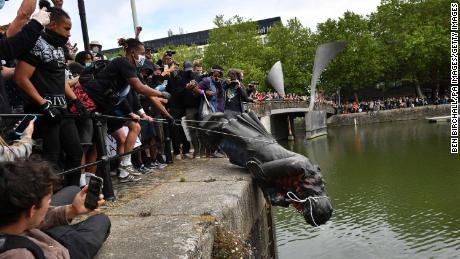 Protesters throw a statue of slave-trader Edward Colston into Bristol harbor during a Black Lives Matter protest in June.