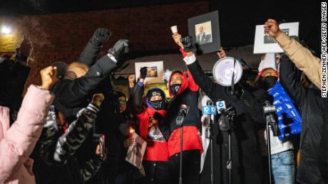 A crowd gathers around Andre Hill&#39;s daughter Karissa Hill and nephew Terry Fagain at a news conference and candlelight vigil for Hill on Saturday.